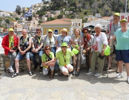 Auf dieses Foto befinden sich die Teilnehmer vor einer tollen Aussicht. Man erkennt im Hintergrund die typischen kleinen gelben Häuser und die griechische Landesfahne.
